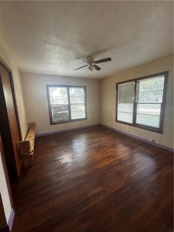 spare room with ceiling fan, dark wood-type flooring, and a textured ceiling