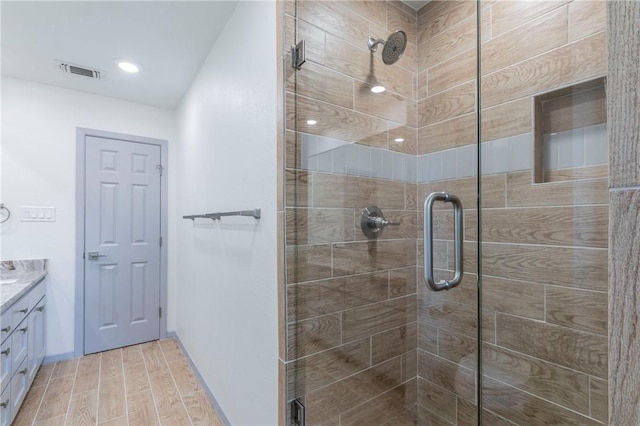 bathroom with vanity, wood-type flooring, and a shower with door