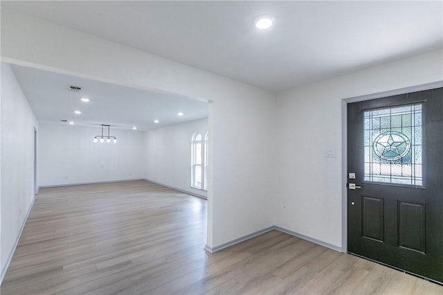 entryway featuring a chandelier and light hardwood / wood-style floors