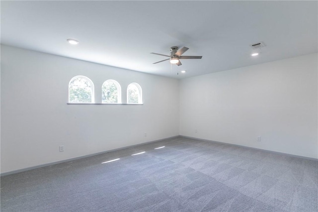 carpeted spare room featuring ceiling fan