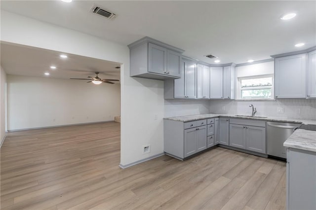 kitchen with light stone countertops, light wood-type flooring, ceiling fan, sink, and dishwasher