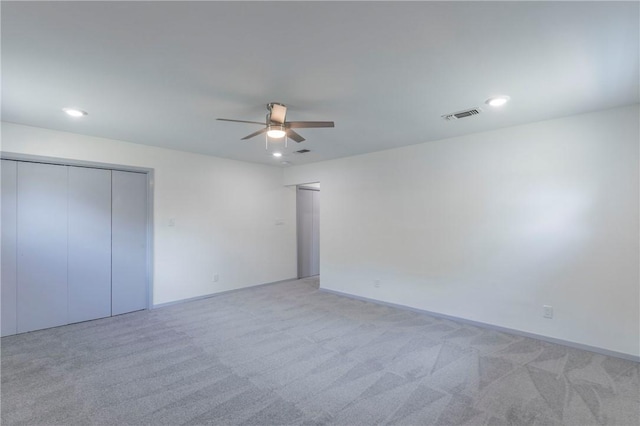 unfurnished bedroom with ceiling fan, a closet, and light carpet