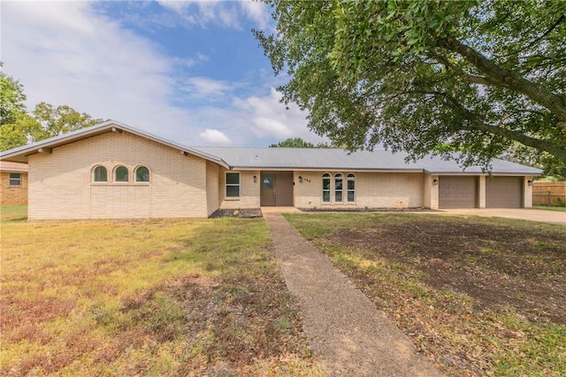 ranch-style house featuring a garage and a front lawn