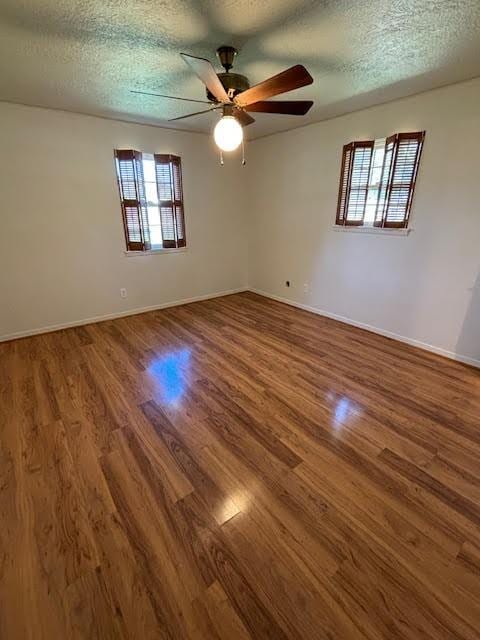 spare room with hardwood / wood-style floors, a textured ceiling, and ceiling fan