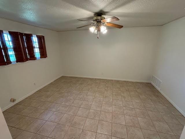 empty room featuring a textured ceiling and ceiling fan