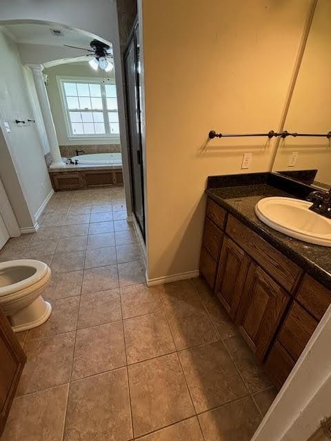 full bathroom with ceiling fan, tile patterned flooring, toilet, vanity, and independent shower and bath