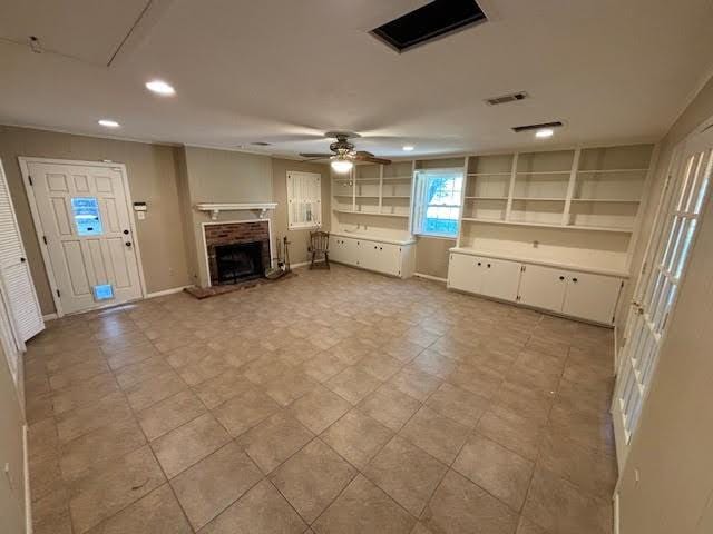 unfurnished living room featuring ceiling fan and a fireplace