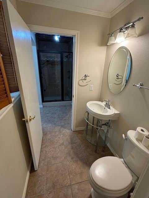 bathroom featuring tile patterned floors, toilet, crown molding, and sink