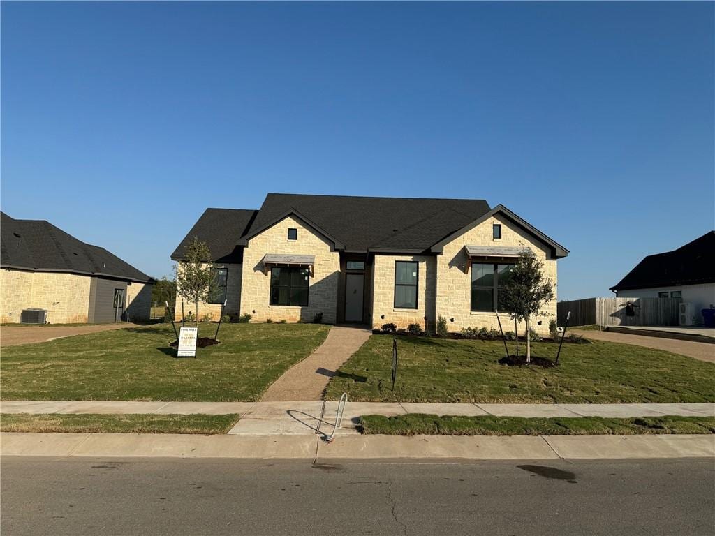 view of front of property with a front lawn and cooling unit