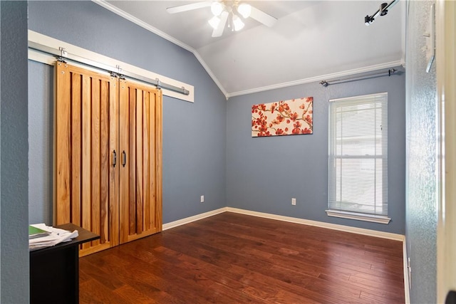 unfurnished room featuring vaulted ceiling, ceiling fan, crown molding, a barn door, and dark hardwood / wood-style floors