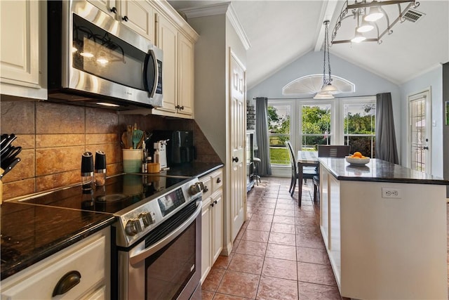 kitchen with cream cabinets, decorative backsplash, light tile patterned floors, appliances with stainless steel finishes, and decorative light fixtures