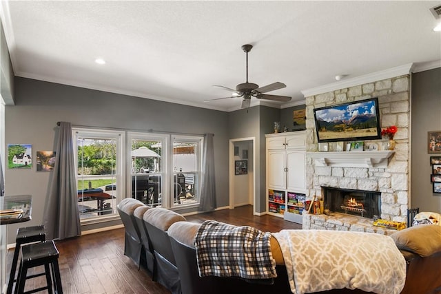 living room with crown molding, ceiling fan, dark hardwood / wood-style flooring, and a fireplace