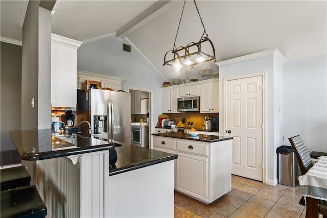 kitchen featuring kitchen peninsula, appliances with stainless steel finishes, vaulted ceiling with beams, and white cabinetry