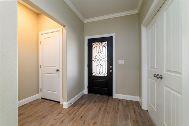 foyer entrance with light hardwood / wood-style flooring and ornamental molding