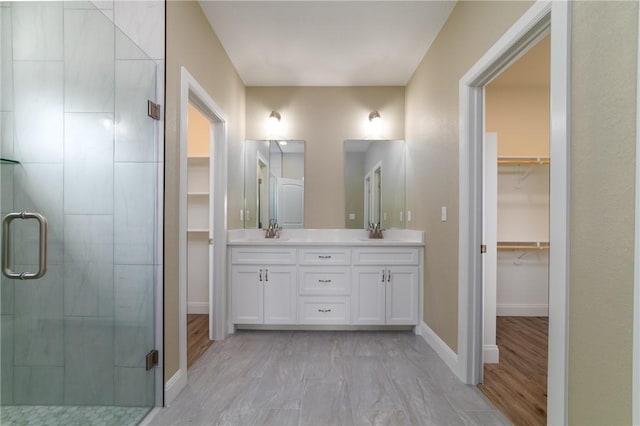 bathroom featuring hardwood / wood-style floors, vanity, and a shower with shower door