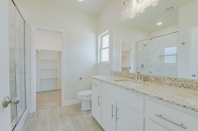 bathroom with toilet, vanity, and walk in shower