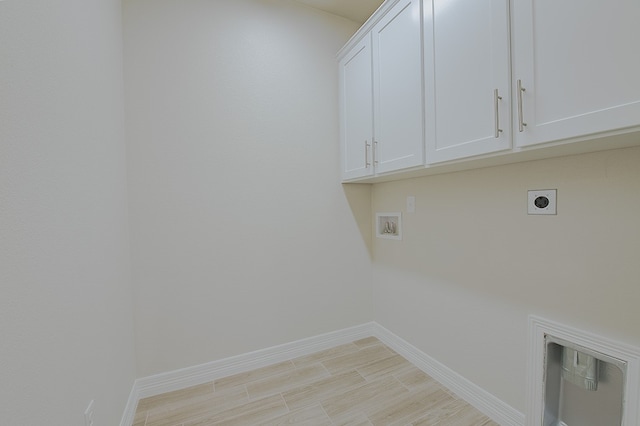 laundry room featuring hookup for an electric dryer, hookup for a washing machine, light hardwood / wood-style flooring, and cabinets