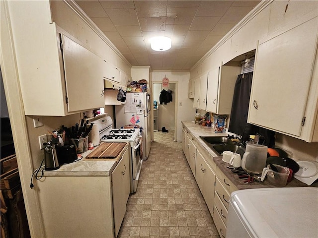 kitchen featuring ornamental molding, sink, and gas range gas stove