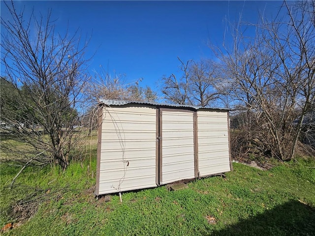 view of outbuilding featuring a lawn