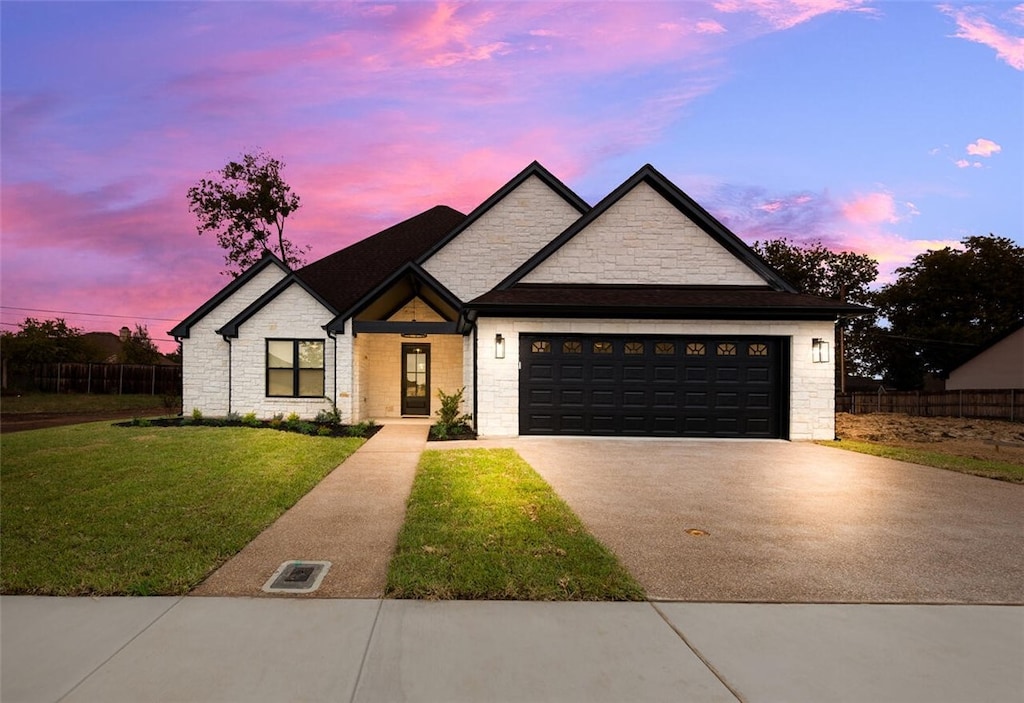 view of front facade with a yard and a garage