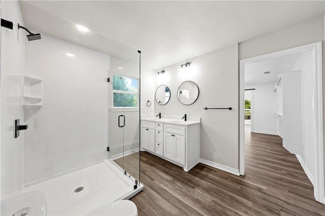 bathroom with hardwood / wood-style flooring, plenty of natural light, and a shower with door