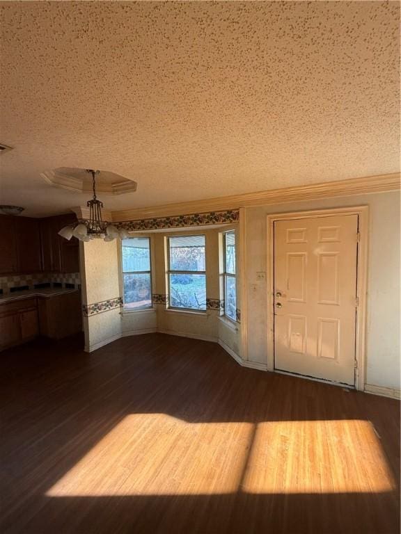 entryway with a textured ceiling, a notable chandelier, and hardwood / wood-style flooring