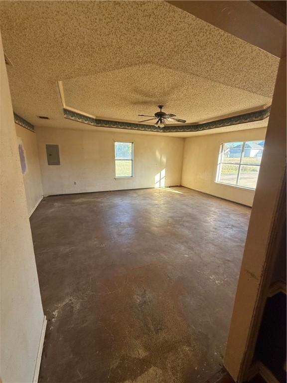 unfurnished room with ceiling fan, a textured ceiling, and electric panel