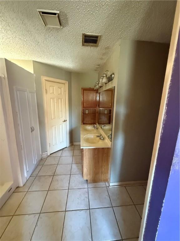 bathroom with tile patterned flooring and a textured ceiling