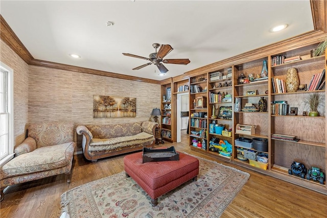 living area featuring ceiling fan, crown molding, and light hardwood / wood-style flooring