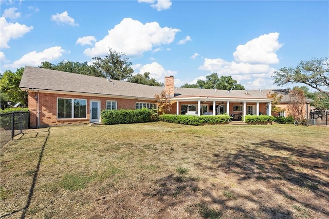 rear view of property with a lawn