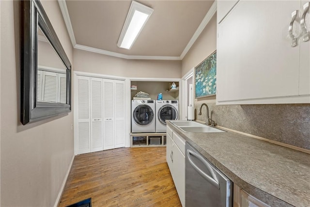 laundry area featuring washer and clothes dryer, ornamental molding, sink, and light hardwood / wood-style flooring