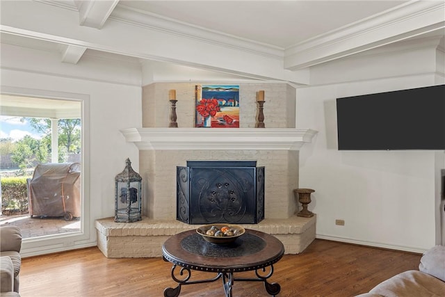 living room with hardwood / wood-style floors, crown molding, and beam ceiling