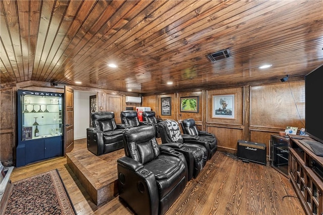 cinema featuring a wall mounted air conditioner, hardwood / wood-style flooring, wood walls, and wood ceiling