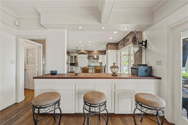 kitchen with a kitchen breakfast bar, white cabinetry, and kitchen peninsula