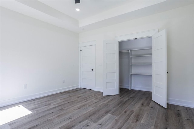 unfurnished bedroom with dark hardwood / wood-style flooring and a closet