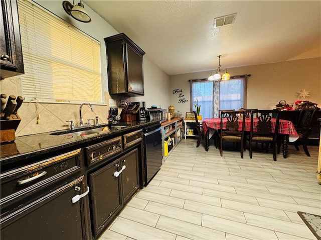 kitchen with sink, an inviting chandelier, black dishwasher, pendant lighting, and dark brown cabinets