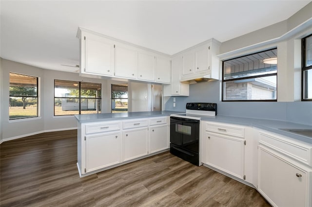 kitchen with kitchen peninsula, white cabinetry, and black range with electric stovetop