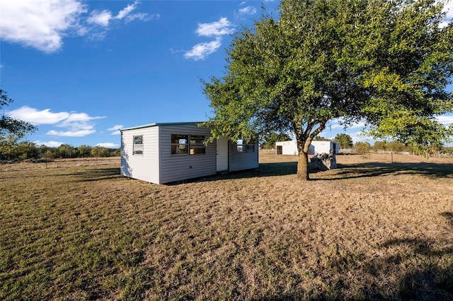 view of yard with a rural view and an outdoor structure