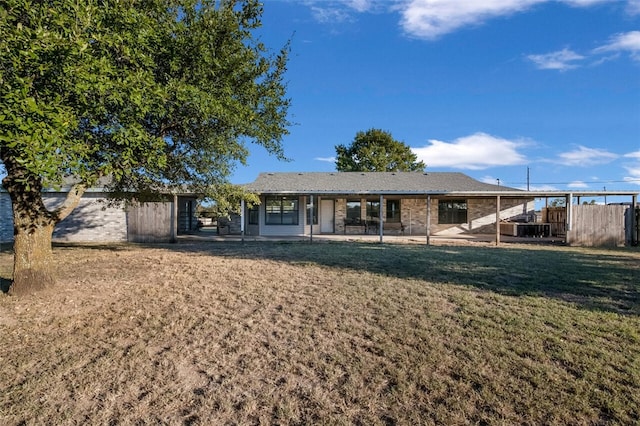 rear view of property featuring a yard