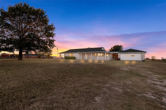 ranch-style home featuring a lawn and a garage