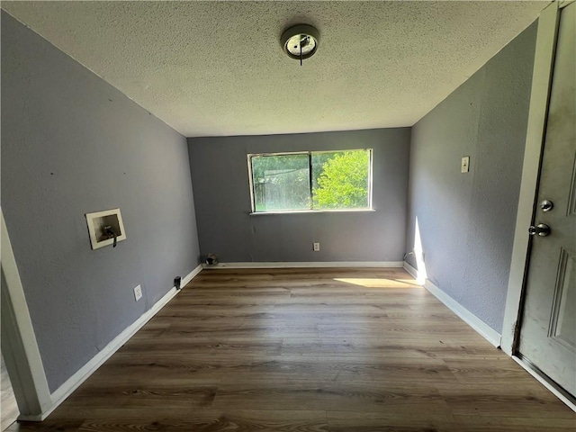 laundry area with wood-type flooring, a textured ceiling, and hookup for a washing machine