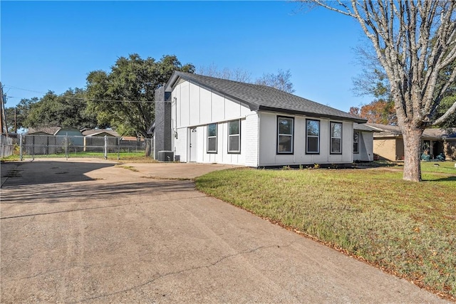 view of front of property featuring a front yard and central AC