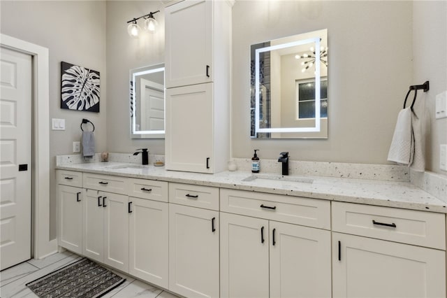 full bathroom with double vanity, marble finish floor, and a sink