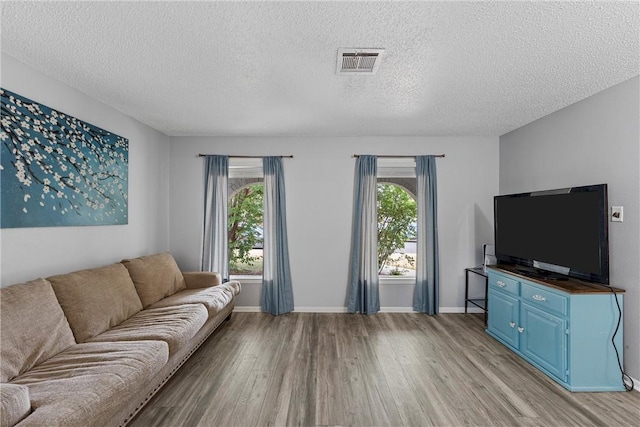 living room with light hardwood / wood-style floors and a textured ceiling