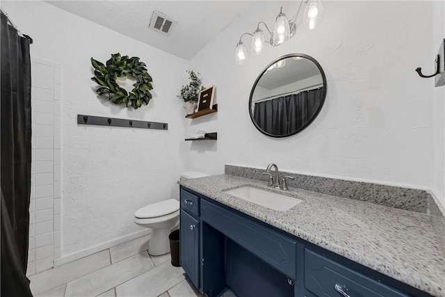 bathroom with tile patterned flooring, vanity, and toilet