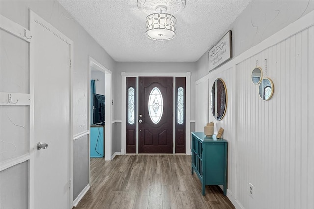 foyer with wood-type flooring and a textured ceiling