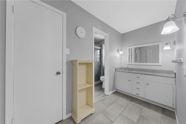 bathroom with tile patterned flooring, vanity, and toilet