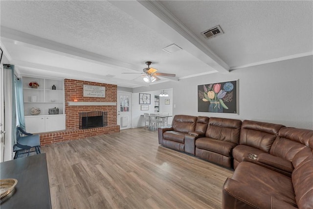 living room with beam ceiling, ceiling fan, a textured ceiling, and light wood-type flooring