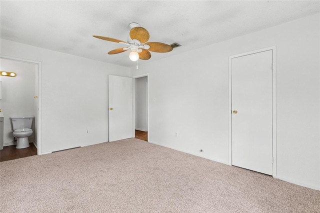 unfurnished bedroom with carpet, connected bathroom, and ceiling fan