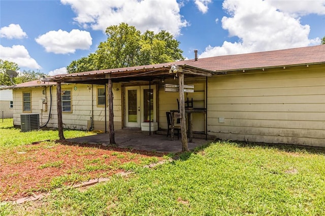 rear view of house with a lawn, a patio area, and central air condition unit